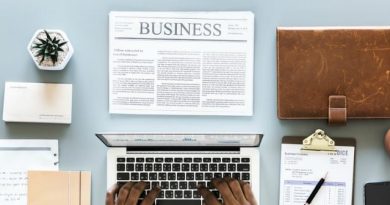 Looking down on desk with person working on laptop - Starting Your Own Home Business