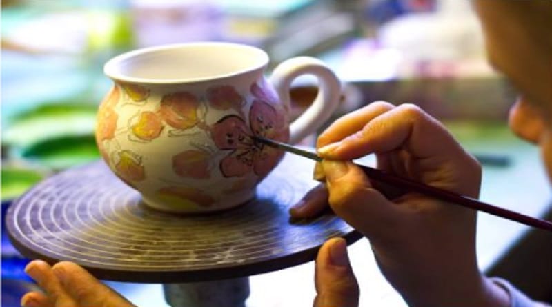 DIY Gifts Artist painting an abstract floral design onto a cup.