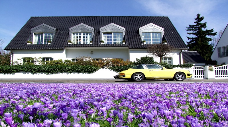 Lovely Villa with Beautiful Purple Flowers and a Yellow Sports Car in the Front