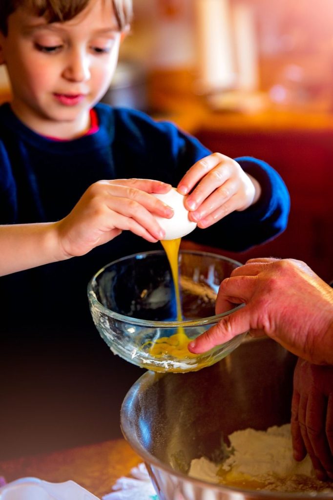 Little boy cracking an egg into a bowl - Giving a Child More Responsibility at Home