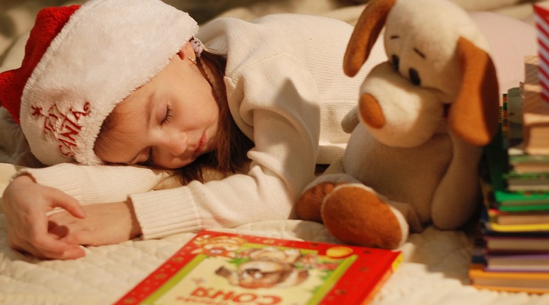 Sleeping Child Wearing a Santa Hat, with books - 2019 Holiday Gift Guide - Great Reads For All Ages
