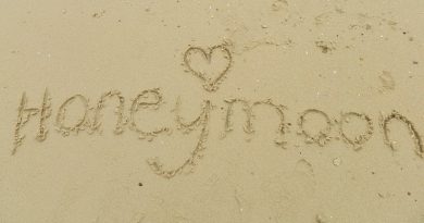 The Word Honeymoon written in the sand.