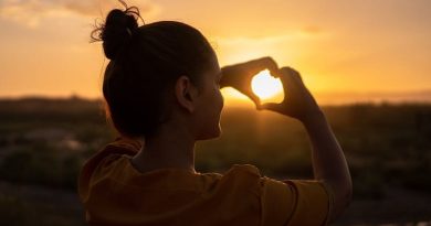 Woman making heart sign with hands.