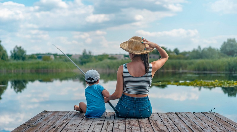 Woman and Little Boy Fishing off Deck on Lake - Learning How to Fish