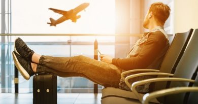 Summer Exchange Programs - College Student in Airport Watching a Plane Take Off Through Window in Waiting Area