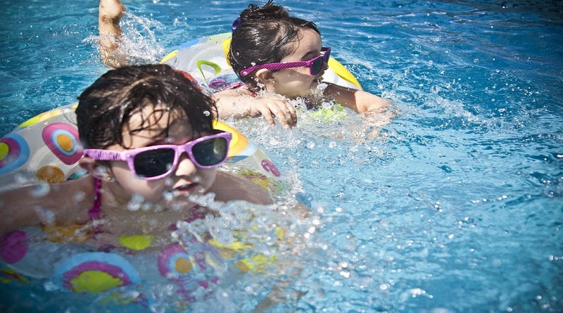 2 little girls wearing pink sunglasses in a pool - De-Winterize your Yard