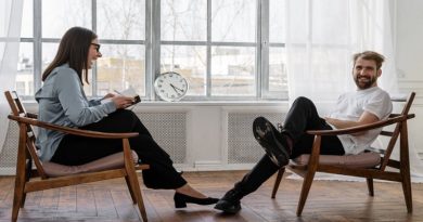 Happy couple in chairs facing each other - Premarital Counseling
