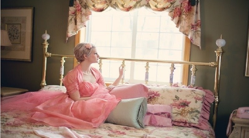 Woman in pink dress on bed with floral Bedspread - Your Bedroom Should Be Brilliant