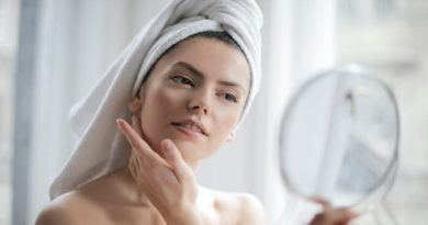 Woman with Towel on Hair Looking Into Mirror - How Your Skin Reacts to Different Seasons