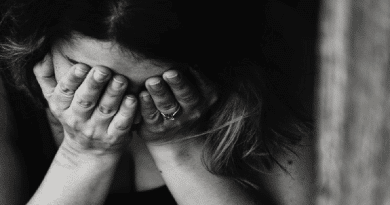 Woman with her head bent down and her hands over her face Signs Your Relationship is Mentally Draining You