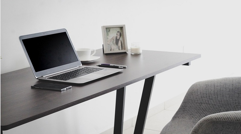 Transforming Your Home Into A Healthy Space Home office with laptop, phone, cup, and photo on simple desk