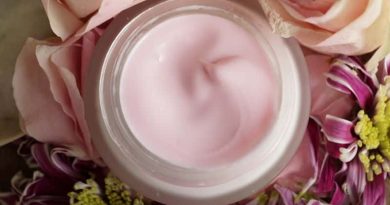 Jar of pink cream surrounded by beautiful flowers