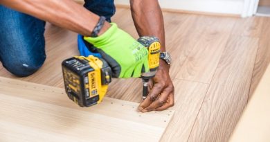 Home Refurbishment Man with drill making holes in a large sheet of wood
