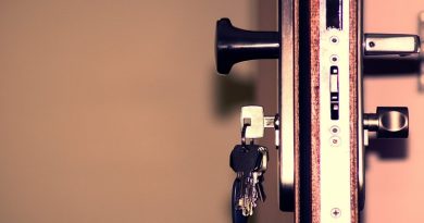 Open door showing locks with keys hanging below the door knob