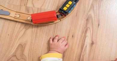 Make Your Home Safer for Kids Childs hand by toy train on train track