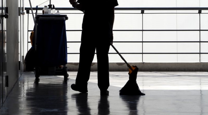 Commercial Cleaning Brisbane Cleaner mopping floor with cleaning cart in background