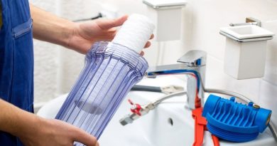 Water Filtration Plumber holding water filter ready for installation