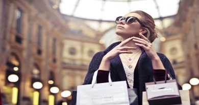 Woman wearing sunglasses and holding numerous shopping bags