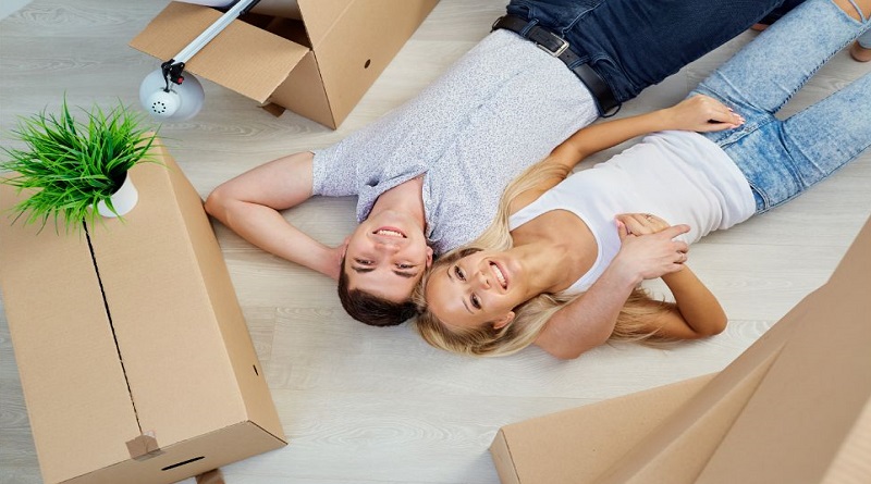 Guide To Moving Out Young couple surrounded by moving boxes