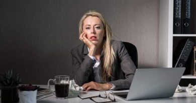 Benefits Of Doing a Job That You Love Bored woman sitting at her desk at work