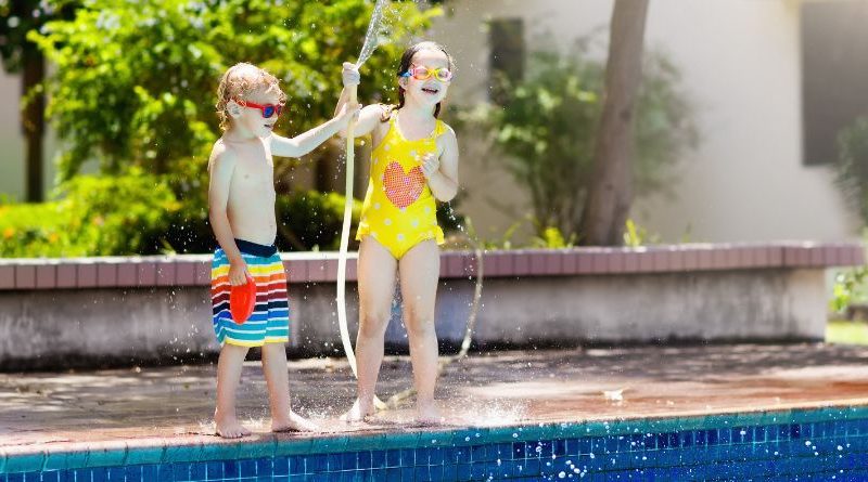 Keeping Your Kids Safe by the Pool Kids playing with water house by backyard swimming pool