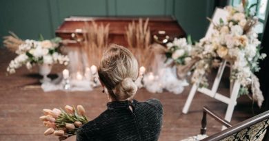 Plan an Amazing Funeral Woman holding flowers gazing at a casket at a funeral