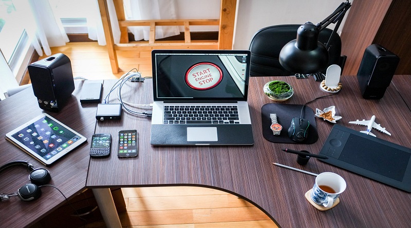 Desk with laptop, tablet, smartphones, mousepad, coffee, headphones and more