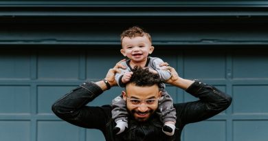 Dad holding toddler on his shoulders