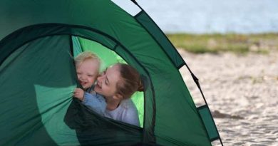 Mom and baby in tent pitched by a lake / Camping with Babies