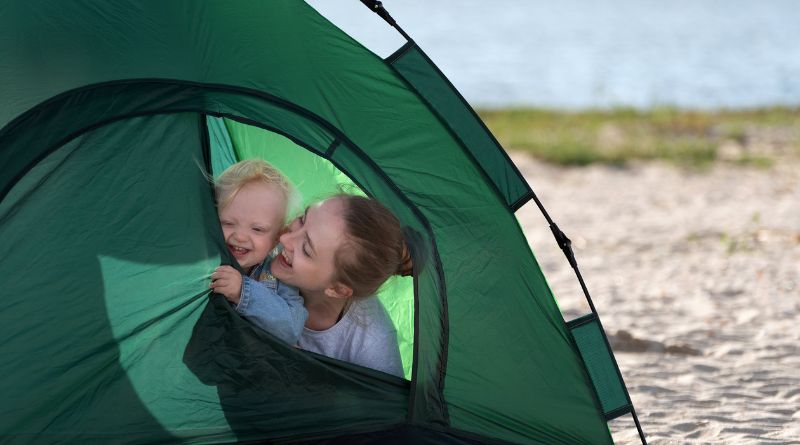 Mom and baby in tent pitched by a lake / Camping with Babies