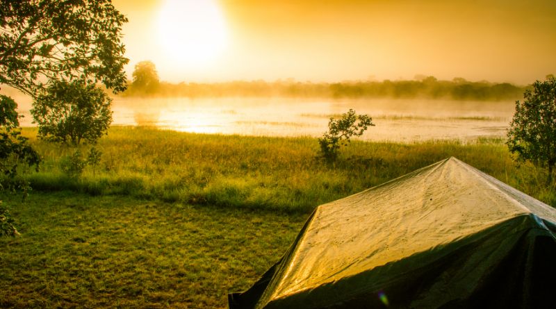 Camping Pitched Tent by a Lake at Sunrise