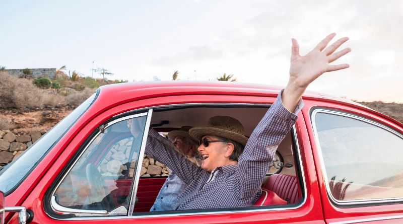 Get The Most Out Of Your Retirement / Senior Adults Having Fun in a Red Car Road Trip