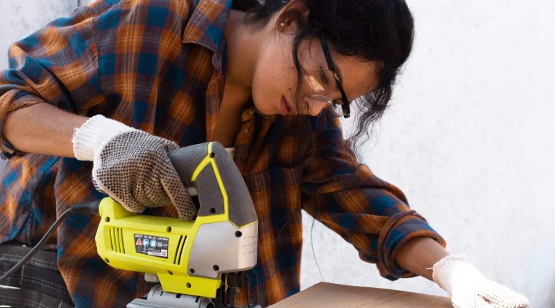 Woman cutting wood with jigsaw