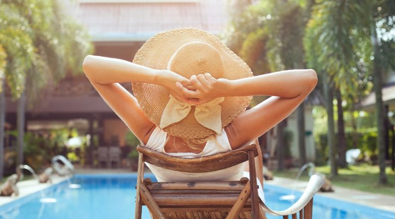 Swimwear Ideas for Summer 2022 . Woman with large sunhat sitting by a pool