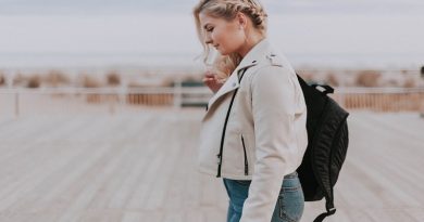Essential Gear and Equipment You Need for Your Next Trip / Woman in jeans and a jacket carrying a travel backpack