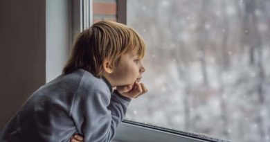 Remove term: Expertly Heat Your Home Expertly Heat Your Home / Young boy in a sweat shirt looking out the window at the snow