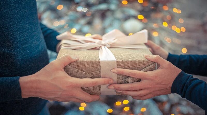 Gift Buying / Two peoples hands holding a wrapped gift