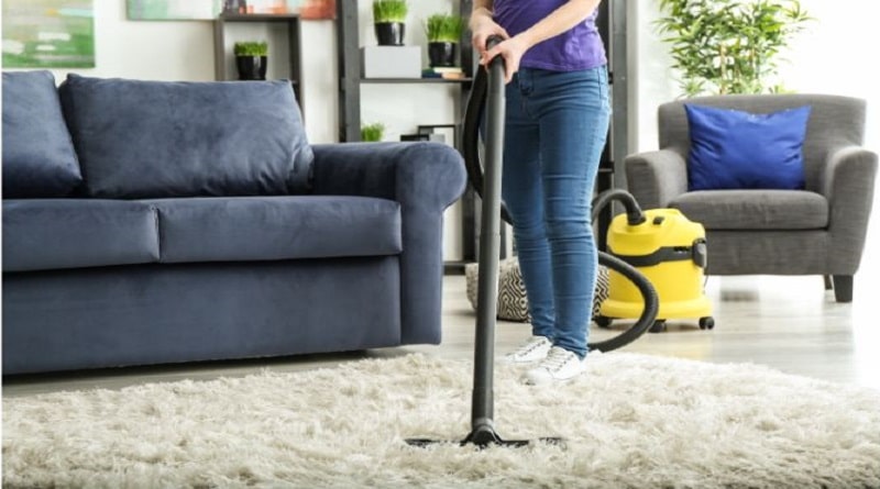 Keeping Your Home Looking Brand New / Woman vacuuming the shag rug in her tidy living room