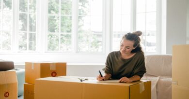 Make Moving to a New Property a Breeze / Woman writing a list surrounded by packing boxes
