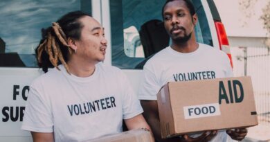 Men wearing volunteer tee shirts holding aid boxes of food
