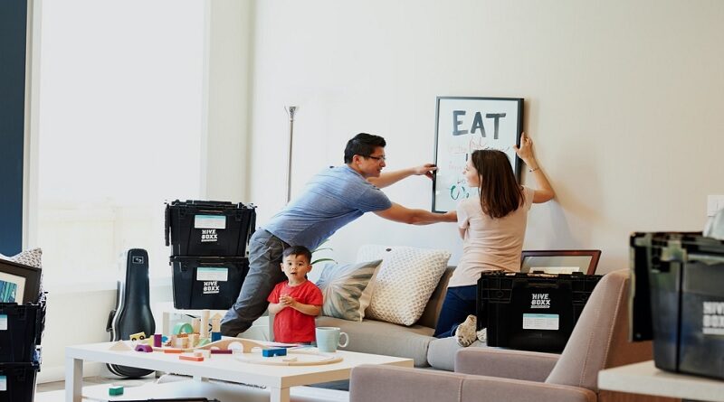 Moving Costs You Need To Be Aware Of / Young couple with small boy arranging their new home