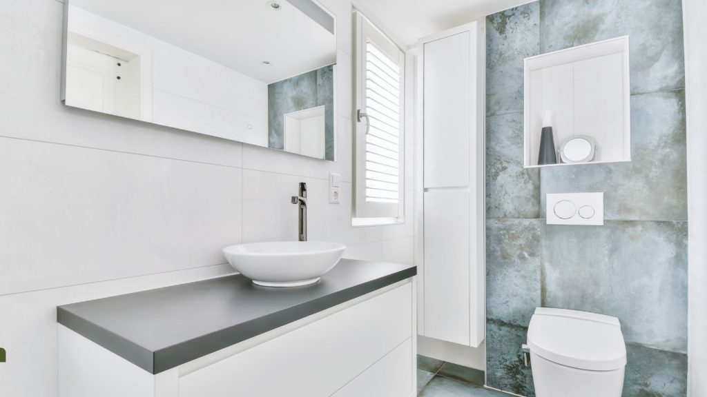 10 Practical Ideas on How to Make Your Small Bathroom Feel Bigger / Small Modern Bathroom in whites and greys with large mirror