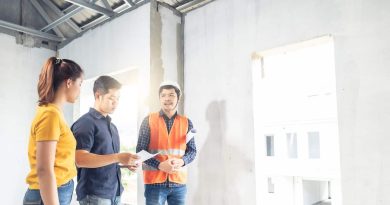 Considerations When Building a Custom Home / Young couple looking at plans and discussing things with their builder