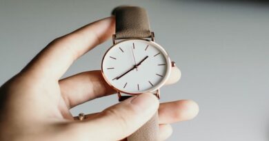 Hand holding a watch with a leather wristband