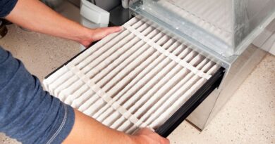 Simple Tips To Make Your Air Conditioner Last Longer / Man putting a new filter into an air conditioner