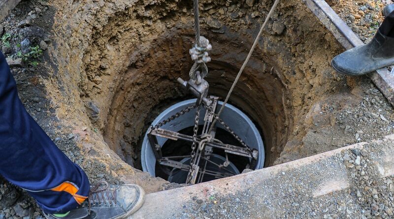 How deep do you have to dig a well for it to fill with water? / Two men digging a well
