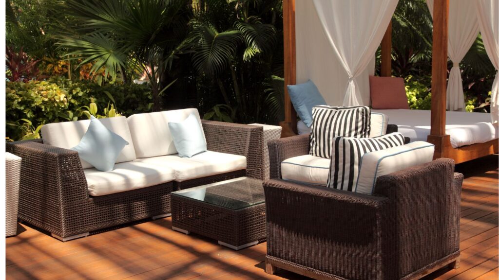 Back Patio with Rattan Furniture, and Outdoor Bed Surrounded by Cream colored Draperies