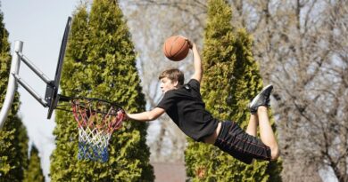 Teenage boy throwing ball through a basketball hoop