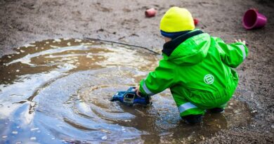 Toddler in a Green snowsuit playing in water and mud / Six Tips to Ensure a Healthy Lifestyle for Your Children