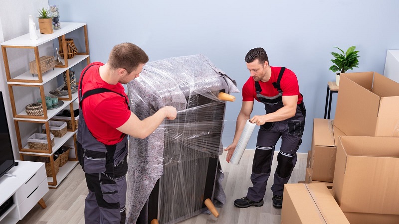 Professional Movers Wrapping a Sofa for Transportation / Discover The Average Cost Of Moving House